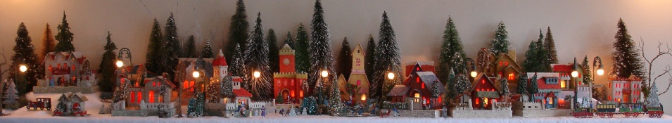 Antique Christmas cardboard house putz (village) on fireplace mantel at night (50K)