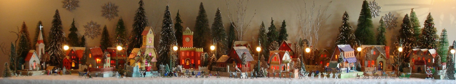 Antique Christmas cardboard house putz (village) on fireplace mantel at night (80K)
